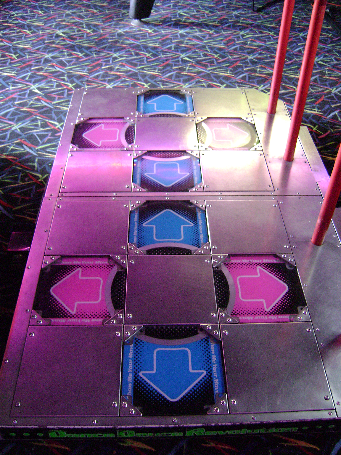 A real Dance Dance Revolution arcade dance platform with glowing directional arrows